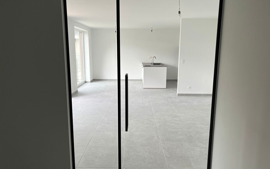 Dit nieuwbouw appartement gelegen in het centrum van Opwijk biedt alle comfort om te wonen op een unieke locatie in het groen. 

Bij binnenkomst begeeft u zich doorheen de ruime inkomhal, via een kwaliteitsvolle afgewerkte glazen deur richting de woonkame